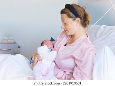 Mother Giving Birth To A Baby. Newborn Baby In Delivery Room. Mom Holding Her New Born Child After Labor. Female Pregnant Patient In A Modern Hospital. Parent And Infant First Moments Of Bonding.