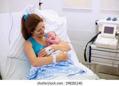 Mother Giving Birth To A Baby. Newborn Baby In Delivery Room. Mom Holding Her New Born Child After Labor. Female Pregnant Patient In A Modern Hospital. Parent And Infant First Moments Of Bonding.