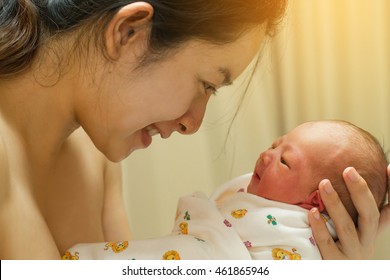 Mother Giving Birth To A Baby. Newborn Baby In Delivery Room. Mom Holding Her New Born Child After Labor. Female Pregnant Patient In A Modern Hospital. Parent And Infant First Moments Of Bonding.