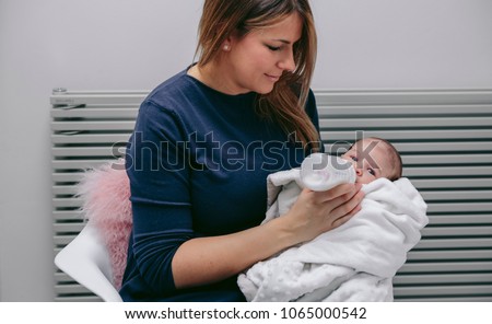 Similar – Image, Stock Photo Mother giving bottle to her newborn