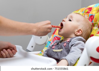mother giving cough syrup with syringe to her sick baby