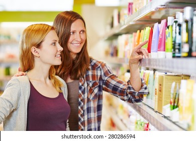 Mother giving her daughter shopping advice in a drugstore - Powered by Shutterstock