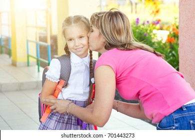 Mother Giving Kiss Goodbye To Children Over School.