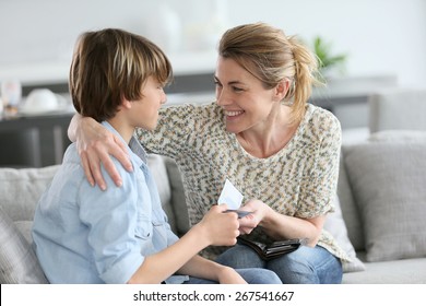 Mother giving money to adolescent for reward - Shutterstock ID 267541667