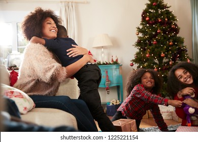 Mother Giving Son Hug As Family Celebrate Christmas At Home Together