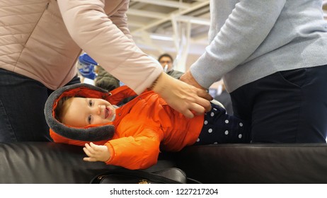 Mother And Grandmother Dressing Happy Little Child Warm Winter Coat