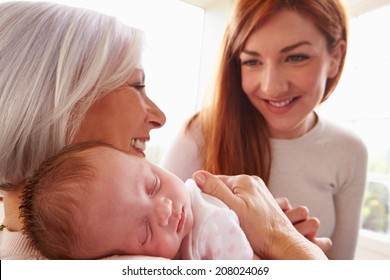 Mother And Grandmother With Sleeping Newborn Baby Daughter