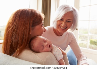 Mother And Grandmother With Sleeping Newborn Baby Daughter