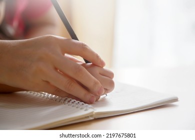 Mother Hand And Child Hand Writing On The Book; Mom Teaching Child How To Write