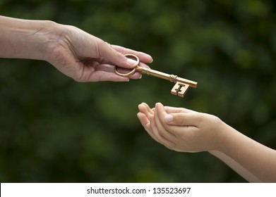 mother handing key to daughter - Shutterstock ID 135523697