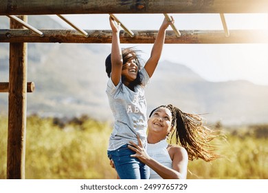 Mother, happy child and play at jungle gym for support, energy or exercise with family at park. African mom, girl and kid at playground or climbing on monkey bar for health, help or laugh with parent - Powered by Shutterstock