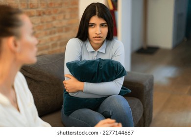 Mother having serious conversation with her teen girl daughter while sitting together on sofa at home, lady hugging pillow and looking at mom. Problems between parents and teenagers - Powered by Shutterstock