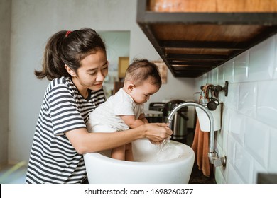 Mother Help Her Baby To Wash Hand In The Sink