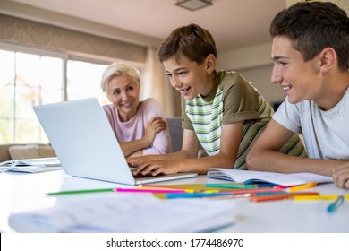 Mother Helping Her Kids Doing Homework At Home
