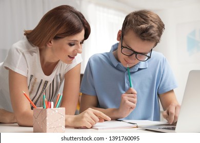 Mother Helping Her Teenager Son With Homework Indoors