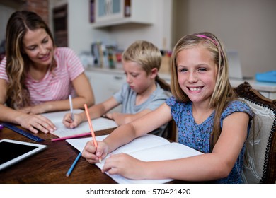 Mutter hilft Kindern bei ihren Hausaufgaben zu Hause