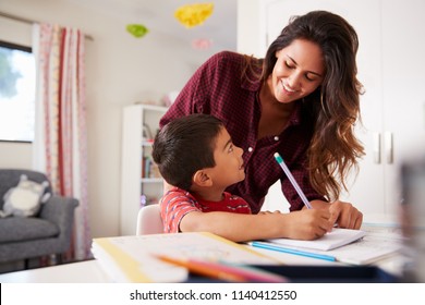 Mother Helping Son With Homework Sitting At Desk In Bedroom - Powered by Shutterstock