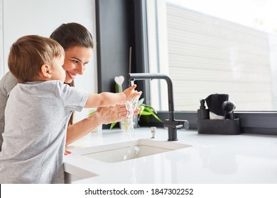 Mother helps child wash hands with soap as hygiene against Covid-19 - Powered by Shutterstock