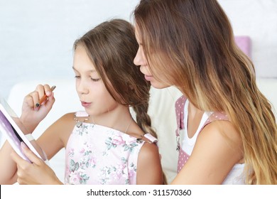 Mother Helps Her Preteen Daughter Learning Ipad Together