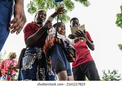 A Mother Helps To Weigh Her Child During The Health And Nutrition Day In Newala District, Mtwara Region, Tanzania On February 23, 2022