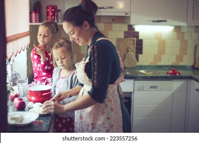 Mother With Her 5 Years Old Kids Cooking Holiday Pie In The Kitchen To Mothers Day, Casual Lifestyle Photo Series In Real Life Interior