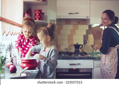 Mother With Her 5 Years Old Kids Cooking Holiday Pie In The Kitchen, Casual Lifestyle Photo Series In Real Life Interior