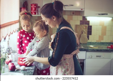 Mother With Her 5 Years Old Kids Cooking Holiday Pie In The Kitchen To Mothers Day, Casual Lifestyle Photo Series In Real Life Interior