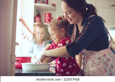 Mother With Her 5 Years Old Kids Cooking Holiday Pie In The Kitchen To Mothers Day, Casual Lifestyle Photo Series In Real Life Interior