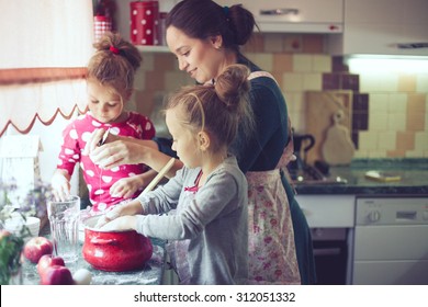 Mother With Her 5 Years Old Kids Cooking Holiday Pie In The Kitchen, Casual Lifestyle Photo Series In Real Life Interior