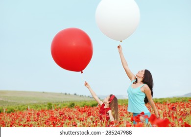 Mother and her 7 years old preteen child playing with big balloons in spring flower field - Powered by Shutterstock