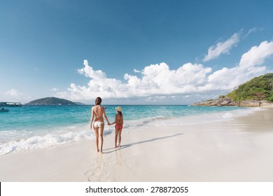 Mother with her 8 years old daughter resting on a tropical beach during summer vacations