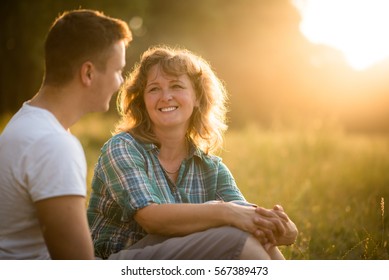 Mother With Her Adult Son Against Nature Background. Family Bond Concept.