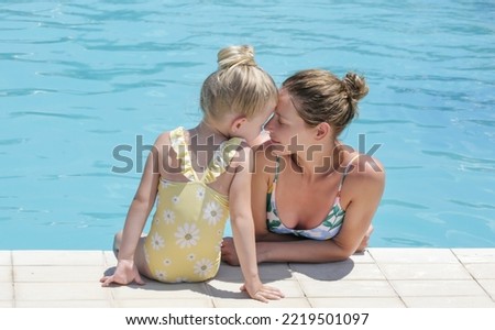 Mother and her baby girl enjoying a day at the pool, summer vacation concept	