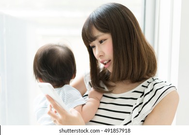 Mother With Her Baby Holding Smart Phone