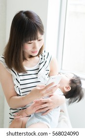 Mother With Her Baby Holding Smart Phone