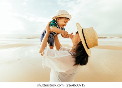 Mother and her baby son playing on the beach during summer vacation - Powered by Shutterstock