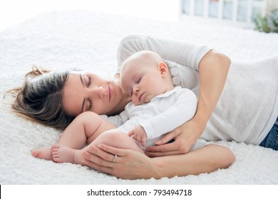 Mother And Her Baby Son, Sleeping On A Big Bed, Soft Back Light Behind Them