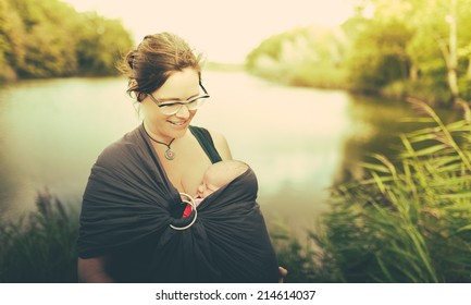 Mother With Her Child Baby In A Carrier