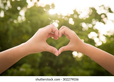 Mother And Her Child Holding Hands In Heart Shape Framing On Nature Background