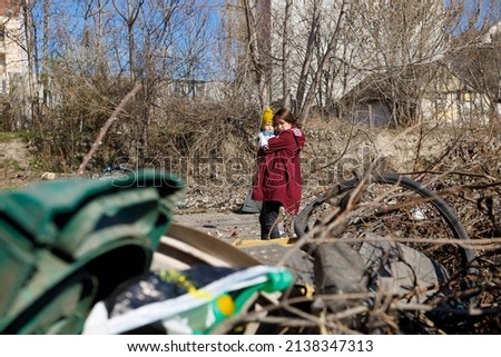 A mother and her child looking at the devastated ruins