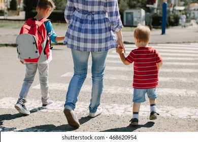 Mother and her children crossing road on way to school