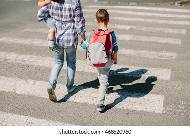 Mother And Her Children Crossing Road On Way To School