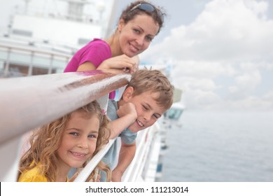 Mother with her children stand on deck of large passenger ship near handrails, focus on girl