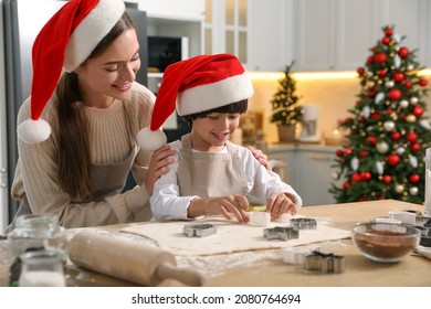 Mother with her cute little son making Christmas cookies in kitchen - Powered by Shutterstock