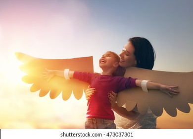 Mother and her daughter child playing together. Little girl plays in the bird. Happy loving family having fun.