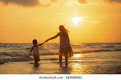 Mother With Her Daughter On The Beach