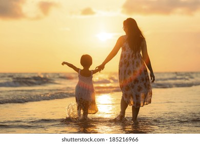 Mother With Her Daughter On The Beach