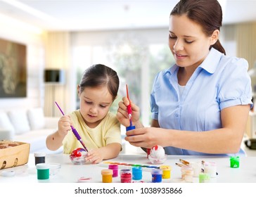 Mother and her daughter painting eggs - Shutterstock ID 1038935866