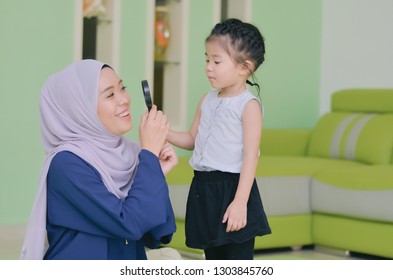 A mother with her daughter play around the house withe selective focus and depth of field - Shutterstock ID 1303845760