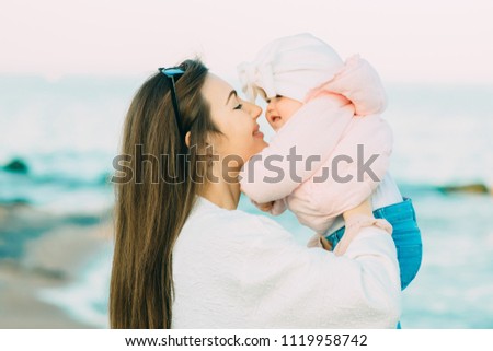 Mother with her daughter playing on the beach.